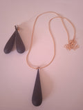 l'ensemble collier pendentif noir allongée femme noir accompagner de son boucle d'oreille noir et doré allongée